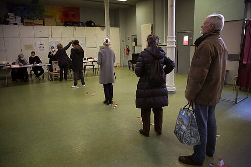 People wait in line to vote for local elections March 15, 2020, in Paris. (AP Photo/Christophe Ena)
