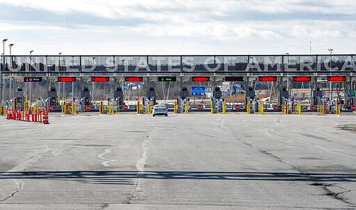 A vehicle approaches the only open lane at the United States border crossing in Lacolle, Quebec, Wednesday, March 18, 2020. The Canada-U.S. border will be closed to non-essential traffic in both directions &quot;by mutual consent,&quot; President Donald Trump confirmed Wednesday, as efforts across the continent to contain the widening COVID-19 pandemic continued to upend daily life in North America. (Ryan Remiorz/The Canadian Press via AP)