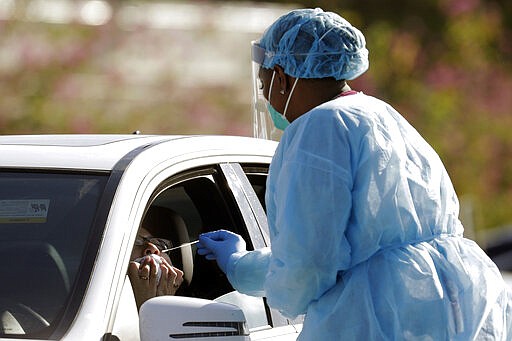 Dr. Jana Cua, left, is swabbed as she is tested for COVID-19 at the Doris Ison Health Center, Wednesday, March 18, 2020, in Miami. The testing is being provided by Community Health of South Florida, Inc. The vast majority of people recover from the new coronavirus. According to the World Health Organization, most people recover in about two to six weeks, depending on the severity of the illness. (AP Photo/Lynne Sladky)