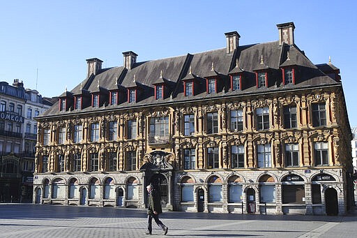 A man walks in a deserted main square in Lille, northern France, Wednesday, March 18, 2020. For most people, the new coronavirus causes only mild or moderate symptoms. For some it can cause more severe illness. (AP Photo/Michel Spingler)