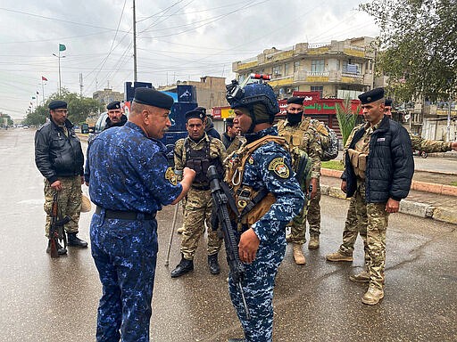 An officer gives orders to the policemen to impose a curfew in Baghdad, Iraq, Wednesday, March 18, 2020. Iraq announced a weeklong curfew to help fight the spread of the coronavirus. For most people, the virus causes only mild or moderate symptoms. For some it can cause more severe illness. (AP Photo/Khalid Mohammed)