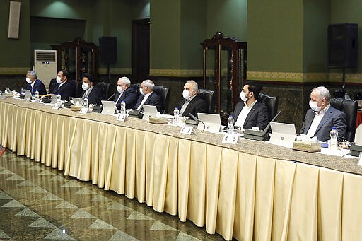 In this photo released by the official website of the Office of the Iranian Presidency, cabinet members wearing face masks attend their meeting in Tehran, Iran, Wednesday, March 18, 2020. For most people, the new coronavirus causes only mild or moderate symptoms. For some it can cause more severe illness. (Office of the Iranian Presidency via AP)