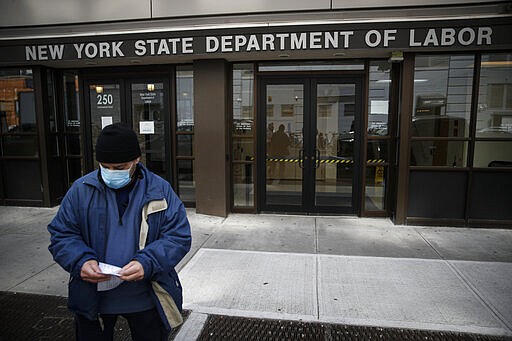 Visitors to the Department of Labor are turned away at the door by personnel due to closures over coronavirus concerns, Wednesday, March 18, 2020, in New York. Applications for jobless benefits are surging in some states as coronavirus concerns shake the U.S. economy. The sharp increase comes as governments have ordered millions of workers, students and shoppers to stay home as a precaution against spreading the virus that causes the COVID-19 disease.  (AP Photo/John Minchillo)