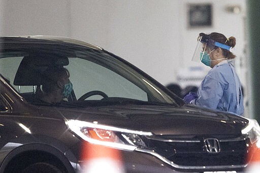 A person is given a test for COVID-19  coronavirus at a drive through testing location Wednesday, March 18, 2020, in Marietta, Ga. The testing is not open to the public people must be referred by the health department. (AP Photo/John Bazemore)