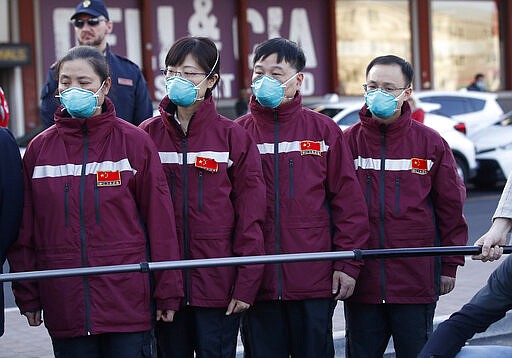 Medics and paramedics from China arrive at the Malpensa airport of Milan, Wednesday, March 18, 2020. Some 37 between doctors and paramedics were sent along with some 20 tons of equipment, and will be deployed to different hospitals in Italy's most affected area. For most people, the new coronavirus causes only mild or moderate symptoms. For some it can cause more severe illness, especially in older adults and people with existing health problems.  (AP Photo/Antonio Calanni)