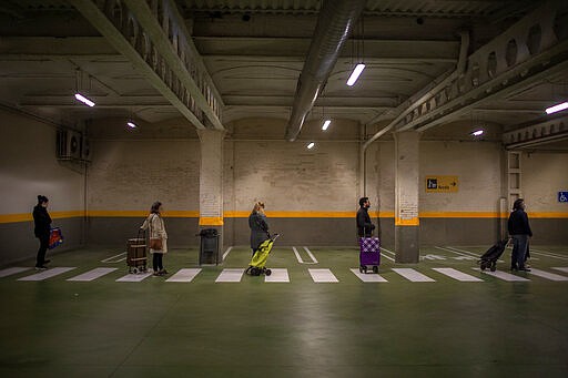 People line up to enter in a shop to buy supplies in Barcelona, Spain, March 17, 2020. (AP Photo/Emilio Morenatti)