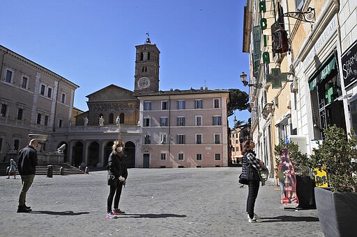 People wear masks as they line up to enter a pharmacy, in Rome, March 16, 2020. (AP Photo/Alessandra Tarantino)