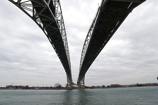 The twin spans of the Blue Water Bridge loom over the St. Clair River in Port Huron, Mich., looking to Sarnia, Ontario, Canada, Wednesday, March 18, 2020. The Canada-U.S. border will be closed to non-essential traffic in both directions &quot;by mutual consent,&quot; the leaders of both countries confirmed Wednesday as efforts across the continent to contain COVID-19. (AP Photo/Paul Sancya)