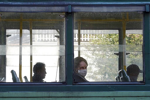 Passengers sit in a tram, in Rome, Wednesday, March 18, 2020. For most people, the new coronavirus causes only mild or moderate symptoms. For some it can cause more severe illness, especially in older adults and people with existing health problems.(AP Photo/Andrew Medichini)