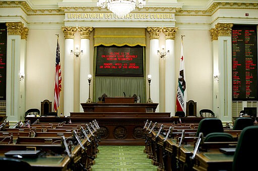 The state Assembly Chambers sits empty at the Capitol in Sacramento, Calif., Wednesday, March 18, 2020. In a precautionary effort to deal with the coronavirus, the Capitol and Legislative Office Building were closed to the public with only essential state workers and legislative employees allowed in until further notice, based on a &quot;stay at home&quot; directive issued by Sacramento County. (AP Photo/Rich Pedroncelli)