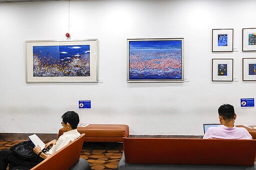 In this March 16, 2020, photo, visitors observe new social distancing measures recommended at the National Library in Singapore. As the virus outbreak spreads ever further, it's becoming clear that some strategies are more likely to succeed in containing it: pro-active efforts to track down and isolate cases, access to basic, affordable public health and clear, reassuring messaging from leaders. (AP Photo/Ee Ming Toh)