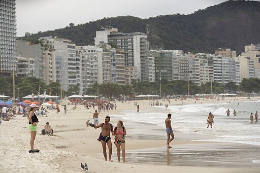 People enjoy Copacabana beach, in Rio de Janeiro, Brazil, Tuesday, March 17, 2020. Brazil has recorded its first death related to the new coronavirus outbreak, according to Sao Paulo state's government. For most people, the new coronavirus causes only mild or moderate symptoms, such as fever and cough. For some, especially older adults and people with existing health problems, it can cause more severe illness, including pneumonia. (AP Photo/Silvia Izquierdo)