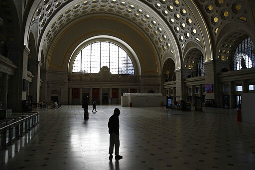 FILE - In this March 16, 2020. file photo, people walk in Union Station's Main Hall in Washington. (AP Photo/Patrick Semansky, File)