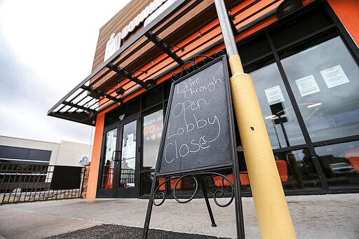 This Tuesday, March 17, 2020 photo shows the Dunkin Donuts restaurant that has closed its lobby but has its drive-through window open in Las Cruces, N.M. Restaurants and bars sat empty this week after New Mexico Gov. Michelle Lujan Grisham ordered them to serve takeout only amid the novel coronavirus outbreak. (Nathan J. Fish/Las Cruces Sun-News via AP)