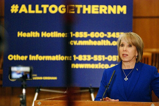 New Mexico Gov. Michelle Lujan Grisham confirmed a new coronavirus infection that has no apparent link to travel on Wednesday, March 18, 2020, during a news conference on the floor of the state House of Representatives in Santa Fe, N.M. She also issued orders to limit the spread of the contagion by restricting restaurants to take-out service and closing down movie theaters, gyms, spas and shopping malls. New Mexico is bracing for the possible spread of coronavirus to some of America's most remote, impoverished communities, as hospitals across the state prepare to convert operating rooms into acute respiratory care units. (AP Photo/Morgan Lee)