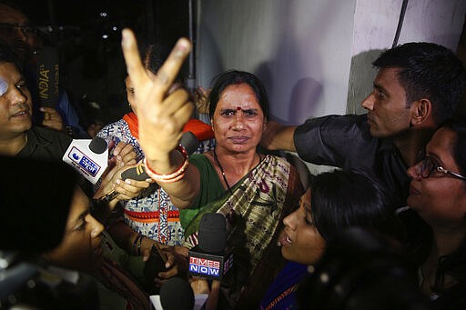 Asha Devi, mother of the victim of the fatal 2012 gang rape on a moving bus, displays a victory sign after the rapists of her daughter were hanged in New Delhi, India, Friday, March 20, 2020. Four men were sentenced to capital punishment for the 2012 gang-rape of a 23-year-old physiotherapy student on a moving bus in New Delhi have been executed. (AP Photo/Altaf Qadri)