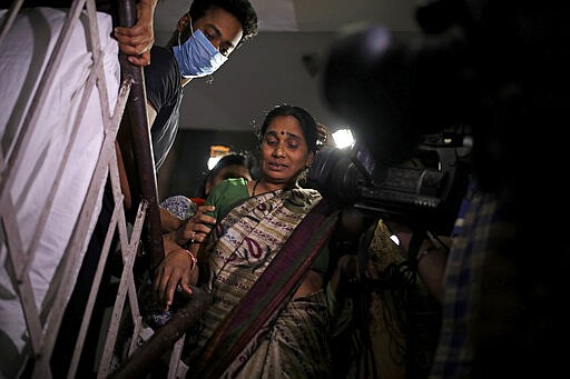 Asha Devi, mother of the victim of the fatal 2012 gang rape on a moving bus, facing camera, is crowded by journalists as she comes out of her home after the rapists of her daughter were hanged, in New Delhi, India, Friday, March 20, 2020. Four men were sentenced to capital punishment for the 2012 gang-rape of a 23-year-old physiotherapy student on a moving bus in New Delhi have been executed. (AP Photo/Altaf Qadri)