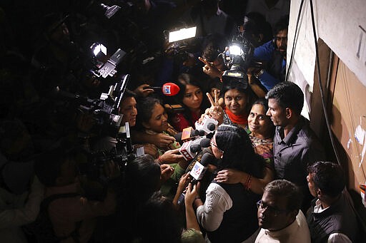 Asha Devi, mother of the victim of the fatal 2012 gang rape on a moving bus, is surrounded by journalists as she displays a victory sign after the rapists of her daughter were hanged in New Delhi, India, Friday, March 20, 2020. Four men were sentenced to capital punishment for the 2012 gang-rape of a 23-year-old physiotherapy student on a moving bus in New Delhi have been executed. (AP Photo/Altaf Qadri)