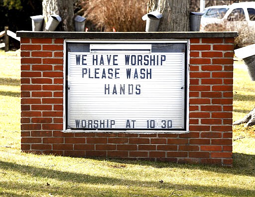 FILE - This Monday March 16, 2020 file photo shows a reminder regarding personal hygiene in lieu of the spreading COVID-19 coronavirus on the sign outside the Austinburg First United Church in Austinburg Township, Ohio. (Warren Dillaway/The Star-Beacon via AP)