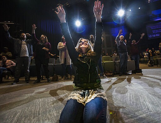 FILE - In this Sunday, March 15, 2020 photo, Heather Davis prays at the altar at the end of a service at Redemption to the Nations church in Chattanooga, Tenn. While most churches around Hamilton County decided to cancel services because of concerns over the COVID-19 coronavirus, Redemption to the Nations stayed open. (Troy Stolt/Chattanooga Times Free Press via AP)