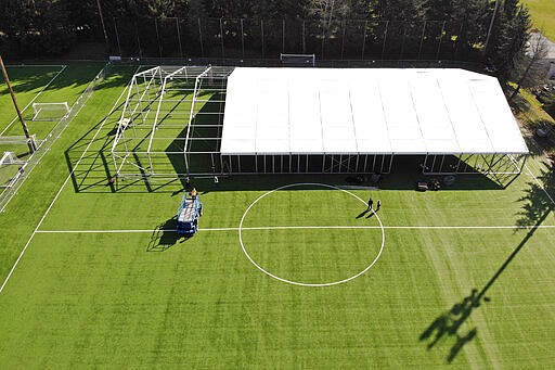 In this aerial drone photo, workers erect a temporary field hospital for use by people unable to isolate and recover from COVID-19 in their own homes on a soccer field Thursday, March 19, 2020, in the Seattle suburb of Shoreline, Wash. The field hospital will provide up to 200 beds, according to a city website, and will house &quot;people exposed to, at risk of exposure, or becoming ill with the novel coronavirus.&quot; (AP Photo/Elaine Thompson)