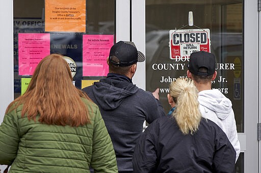 People seeking service find the Douglas County Treasurer's office closed, in Omaha, Neb., Wednesday, March 18, 2020. In-person services were suspended due to the coronavirus outbreak. (AP Photo/Nati Harnik)