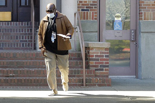 An employee wears a mask as he walks near an entrance to Western State Hospital, Thursday, March 19, 2020, in Lakewood, Wash. A patient and a worker at the facility, Washington state's largest psychiatric hospital, have tested positive for COVID-19. (AP Photo/Ted S. Warren)