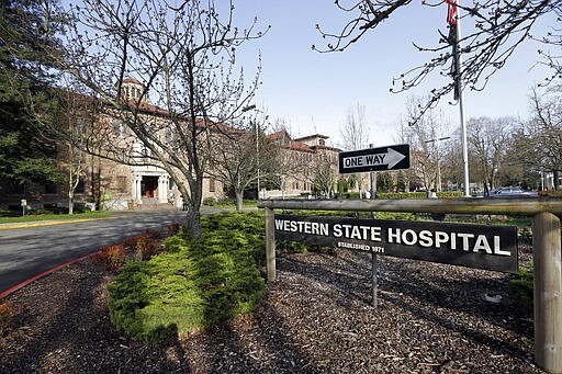 FILE - In this April 11, 2017, file photo, the entrance to Western State Hospital is seen in Lakewood, Wash. A patient as Washington state's largest psychiatric hospital has tested positive for coronavirus. Workers at Western State Hospital fear that number will increase due to a lack of protective gear. (AP Photo/Elaine Thompson, File)