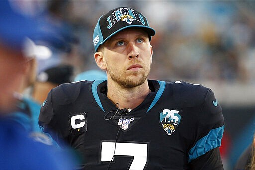 FILE - In this Dec. 8, 2019, file photo, Jacksonville Jaguars quarterback Nick Foles walks along the bench area as he looks up at the scoreboard during the first half of an NFL football game against the Los Angeles Chargers, in Jacksonville, Fla. A person familiar with the trade says the Jacksonville Jaguars have agreed to send quarterback Nick Foles to the Chicago Bears for a compensatory fourth-round draft pick. The person spoke to The Associated Press on condition of anonymity because trades don't become official until the league year begins later Wednesday, March 18, 2020. (AP Photo/Stephen B. Morton, File)