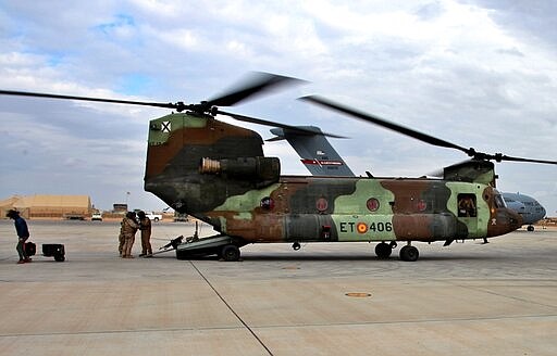 FILE - In this Jan. 13, 2020, file photo, A U.S. Air Force plane, background, lands at Ain al-Asad air base, in Anbar, Iraq. The U.S.-led coalition pulled out from a base in the country's west as part of plans to drawdown on Thursday, March 19, 2020, Iraqi and coalition officials said, while training activities were suspended amid fears of a viral pandemic. (AP Photo/Qassim Abdul-Zahra, File)