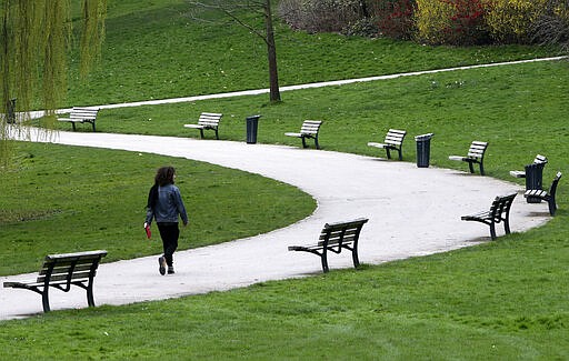 A man walks in a park of Roubaix, northern France, Thursday, March 19, 2020. French President Emmanuel Macron said that for 15 days starting at noon on Tuesday, people will be allowed to leave the place they live only for necessary activities such as shopping for food, going to work or taking a walk. For most people, the new coronavirus causes only mild or moderate symptoms. For some it can cause more severe illness. (AP Photo/Michel Spingler)