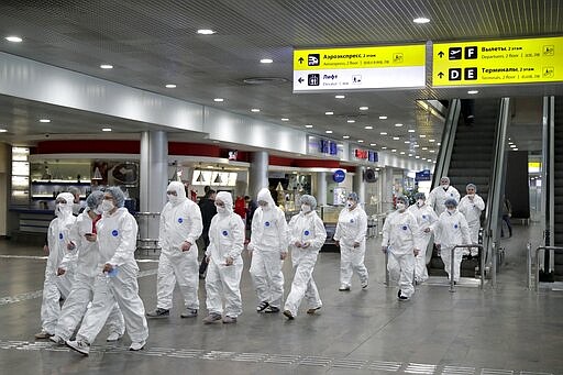 Russian medical experts walk to start their shift to check passengers arriving from foreign countries at Sheremetyevo airport outside Moscow, Russia, Thursday, March 19, 2020. Authorities in Russia are taking vast measures to prevent the spread of the COVID-19 virus in the country. The measures include closing the border for all foreigners, shutting down schools for three weeks, sweeping testing and urging people to stay home. For most people, the new coronavirus causes only mild or moderate symptoms. For some it can cause more severe illness. (AP Photo/Pavel Golovkin)