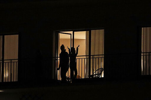 People applaud the caregivers for their work, as the coronavirus ravaged communities across the country, in Ville d'Avray, outside Paris, Thursday, March 19, 2020. In France at 8pm sharp local time French citizens leaned out of windows and dangled from balconies and began applauding and whistling in unison to thank those on the front lines of the pandemic that has already claimed scores of lives. For most people, the new coronavirus causes only mild or moderate symptoms. For some it can cause more severe illness, especially in older adults and people with existing health problems. (AP Photo/Christophe Ena)