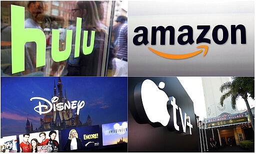 This combination photo shows, clockwise from top left, the Hulu logo on a window at the Milk Studios space in New York, the Amazon logo in Santa Monica, Calif., the Apple TV+ logo displayed outside the Regency Village Theatre in Los Angeles before the premiere of the the Apple TV+ series &quot;See,&quot; and a screen grab of the Disney Plus streaming service on a computer screen. Sports are on hold, movie theaters are closed and so are amusement parks. But Americans held captive at home by the coronavirus can turn to Netflix, Amazon, Hulu and other streaming services, outliers in an entertainment industry otherwise brought to an unprecedented standstill. (AP Photo)