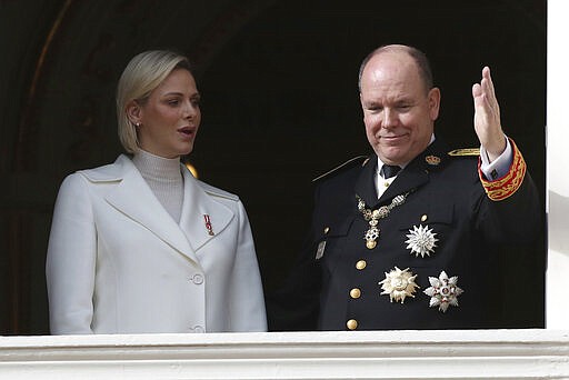 FILE - In this Nov.19, 2019 file photo Prince Albert II of Monaco with his wife Princess Charlene wave from the balcony during the ceremony marking the National Day in Monaco. The palace of Monaco says Prince Albert II has tested positive for the new coronavirus but his health is not worrying. For most people, the new coronavirus causes only mild or moderate symptoms. For some it can cause more severe illness. (AP Photo/Daniel Cole, File)