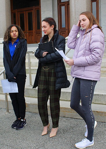 FILE - In this Feb. 12, 2020 file photo, high school track athletes Alanna Smith, left, Selina Soule, center and and Chelsea Mitchell prepare to speak at a news conference outside the Connecticut State Capitol in Hartford, Conn. The three girls have filed a federal lawsuit to block a state policy that allows transgender athletes to compete in girls sports. In a response to their lawsuit, the Connecticut Interscholastic Athletic Conference argued in a court filing that it is not subject to the federal law that guarantees equal access to women and girls in education, including athletics. (AP Photo/Pat Eaton-Robb, File)