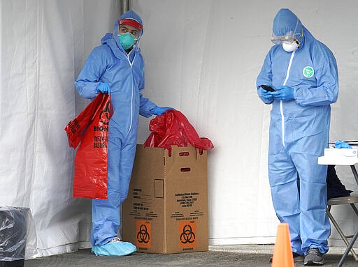 Healthcare professionals prepare to begin testing at a drive-thru testing site for COVID-19 at United Memorial Medical Center Thursday, March 19, 2020, in Houston. For most people, the coronavirus causes only mild or moderate symptoms, such as fever and cough. For some, especially older adults and people with existing health problems, it can cause more severe illness, including pneumonia. (AP Photo/David J. Phillip)