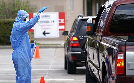 A healthcare professional, left, asks a patient to lower their window during drive thru testing for COVID-19 at United Memorial Medical Center Thursday, March 19, 2020, in Houston. For most people, the coronavirus causes only mild or moderate symptoms, such as fever and cough. For some, especially older adults and people with existing health problems, it can cause more severe illness, including pneumonia. (AP Photo/David J. Phillip)