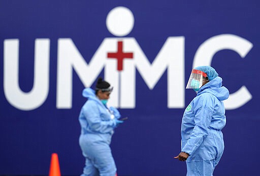 Healthcare professionals prepare to begin testing at a drive-thru testing site for COVID-19 at United Memorial Medical Center Thursday, March 19, 2020, in Houston. For most people, the coronavirus causes only mild or moderate symptoms, such as fever and cough. For some, especially older adults and people with existing health problems, it can cause more severe illness, including pneumonia. (AP Photo/David J. Phillip)