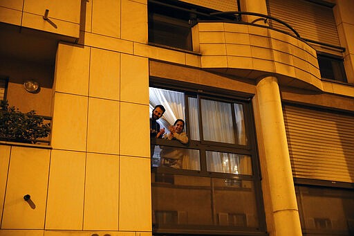 Parisians, in spirit at least, applaud the caregivers and police for their work, as the coronavirus ravaged communities across the country, in Paris, Wednesday, March 18, 2020. In France at 8pm sharp local time French citizens leaned out of windows and dangled from balconies and began applauding and whistling in unison to thank those on the front lines of the pandemic that has already claimed scores of lives. The move was an organized initiative that began circulating on social media. France has been on effective lockdown since midday on Tuesday as French President Emmanuel Macron tightened restrictions on movement to fight the spread of the virus. (AP Photo/Francois Mori)