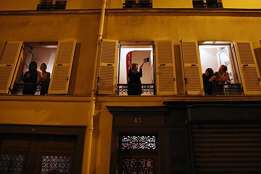 Parisians, in spirit at least, applaud the caregivers and police for their work, as the coronavirus ravaged communities across the country, in Paris, Wednesday, March 18, 2020. In France at 8pm sharp local time French citizens leaned out of windows and dangled from balconies and began applauding and whistling in unison to thank those on the front lines of the pandemic that has already claimed scores of lives. The move was an organized initiative that began circulating on social media. France has been on effective lockdown since midday on Tuesday as French President Emmanuel Macron tightened restrictions on movement to fight the spread of the virus. (AP Photo/Francois Mori)