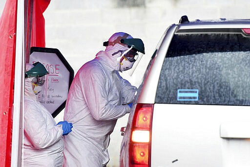 Clinical care providers take swabs for coronavirus on a patient during drive-thru testing by the Fayette County Health Department in Oak Hill, W.V. on Thursday, March 19, 2020. (Chris Jackson/The Register-Herald via AP)