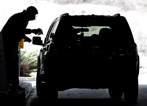 Clinical staff workers conduct a drive-thru COVID-19 test Wednesday, March 18, 2020, at Allegheny Health Network's Wexford Health + Wellness Pavilion in Wexford, Pa. (Steph Chambers/Pittsburgh Post-Gazette via AP)