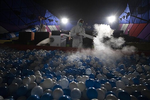 A worker sprays disinfectant as a precaution against the new coronavirus on ball pool for Kids Cinema at Quartier Cineart movie theater in Bangkok, Thailand, Thursday, March 19, 2020. Thailand's government has enacted stronger measures to combat the spread of the coronavirus, including postponing the country's biggest holiday, shutting down schools, movie theaters and closing bars. For most people, the new coronavirus causes only mild or moderate symptoms. For some it can cause more severe illness. (AP Photo/Sakchai Lalit)