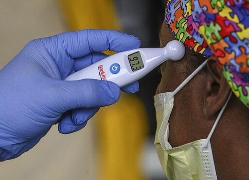 A woman gets her temperature read as normal before going to work at AnMed Health Campus Emergency Department entrance in Anderson, S.C. in Anderson Thursday, March 19, 2020. (Ken Ruinard /The Independent-Mail via AP)