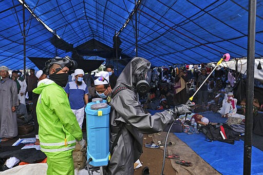 Paramilitary police officers in hazmat suit disinfect a tent built on a field where a mass congregation is supposed to be held in Gowa, South Sulawesi, Indonesia, Thursday, March 19, 2020. Indonesia halted the congregation of thousands of Muslim pilgrims and began quarantining and checking their health Thursday to prevent the spread of the new coronavirus. The vast majority of people recover from the new coronavirus. According to the World Health Organization, most people recover in about two to six weeks, depending on the severity of the illness. (AP Photo/Syaief)