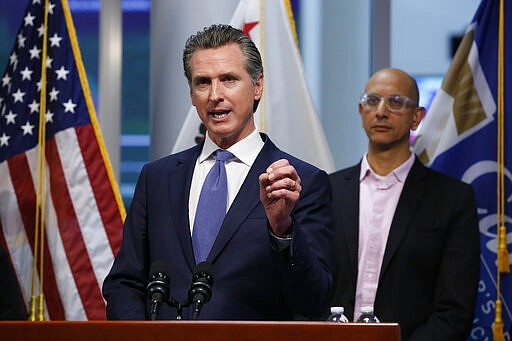 FILE - In this March 17, 2020 file photo, California Gov. Gavin Newsom gives an update to the state's response to the coronavirus at the Governor's Office of Emergency Services in Rancho Cordova Calif. On Tuesday, March 17, when announcing that he had put the National Guard on alert, Newsom said martial law could be used  &quot;if we feel the necessity.&quot;  Martial law is when civil laws are suspended and a military force is in charge. Newsom has asked people to not gather in large numbers and generally stay inside during the coronavirus outbreak, and so far most are obeying. (AP Photo/Rich Pedroncelli, Pool)