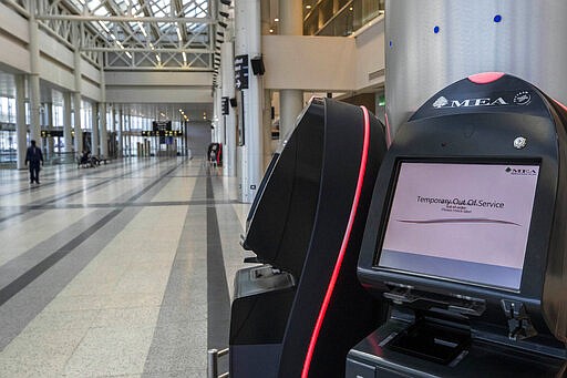 A check-in machine is not working at an empty departure area of Rafik Hariri International Airport, in Beirut, Lebanon, Thursday, March 19, 2020. The Lebanese government decided to shut down the airport, ports and borders and ordered its citizens to stay home as the small country of nearly 5 million grappled with containing the coronavirus. (AP Photo/Hassan Ammar)