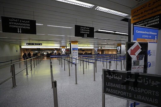 File - In this Monday, March 9, 2020 file photo, a general view shows empty security counters and signage for coronavirus screening at the arrival terminal at the Rafik Hariri International Airport in Beirut, Lebanon. With thousands of flights grounded around the world due to a fast-spreading virus and seven countries in the Middle East suspending all commercial flights, airlines in the region have lost more than $7 billion in revenue, the aviation industry's largest trade association said Thursday. (AP Photo/Hassan Ammar, File)