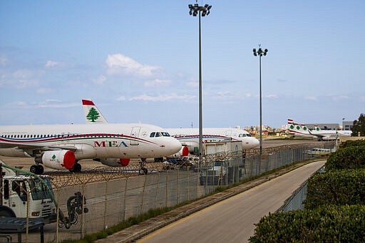 Middle East Airlines jets are parked as no planes are using the Rafik Hariri International Airport in Beirut, Lebanon, Thursday, March 19, 2020. The Lebanese government decided to shut down the airport, ports and borders and ordered its citizens to stay home as the small country of nearly 5 million grappled with containing the coronavirus. (AP Photo/Hassan Ammar)